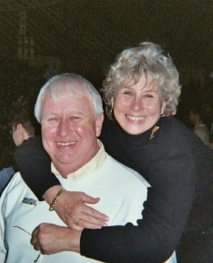 Ro Whittingon stands behind and embraces her husband, Charles 